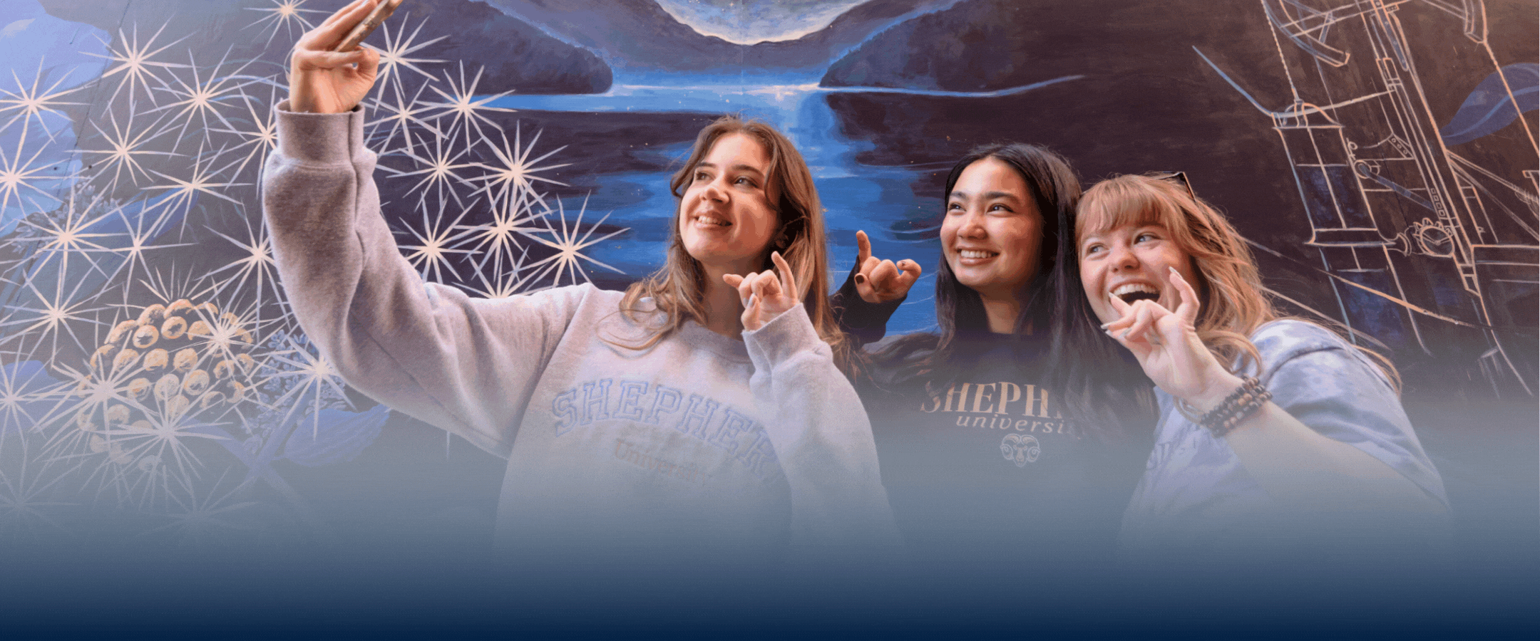 Photo of students at a mural in Shepherdstown with text below, "Welcome to the Ram Fam!"