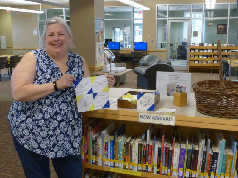 Rhonda Donaldson, Scarborough Library coordinator of research services, holds a set of completed squares for the signature quilt she will sew.