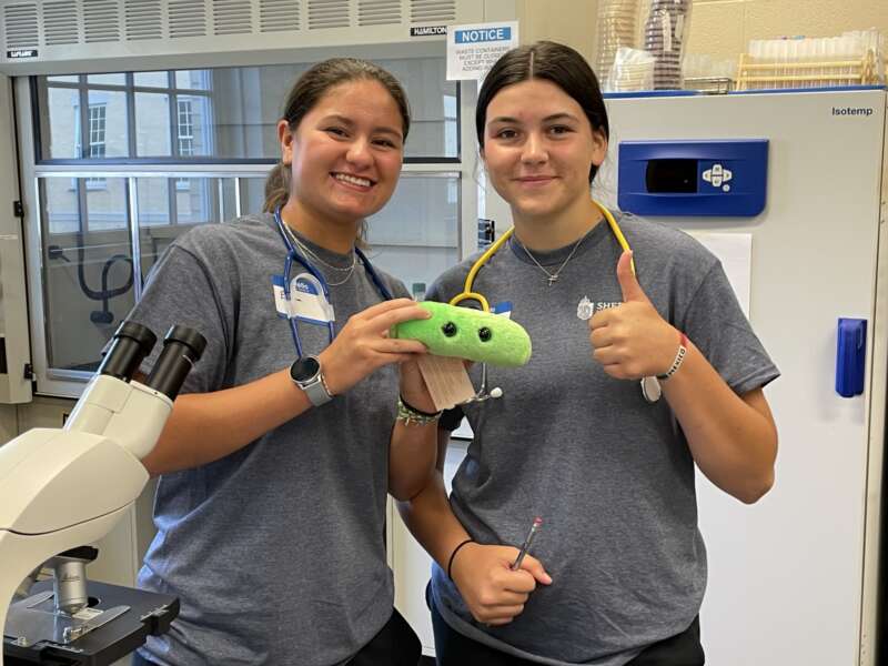 students with green stuffed animal