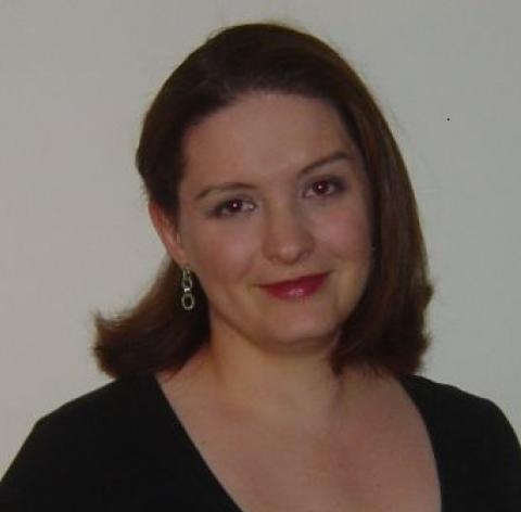 Woman with short dark hair facing and smiling the camera