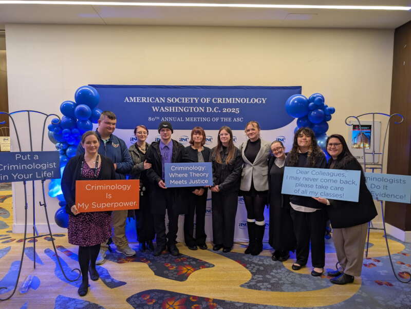 group of people standing in front of blue banner