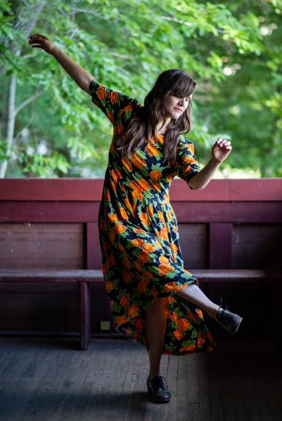 Photo of dancer Becky HIll whearing a flowered print dress dancing. Photo taken by Cory Marie Podielski.