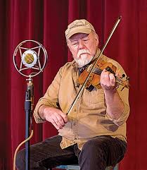 Appalachian master musician Dave Bing plays fiddle while seated in front of a microphone