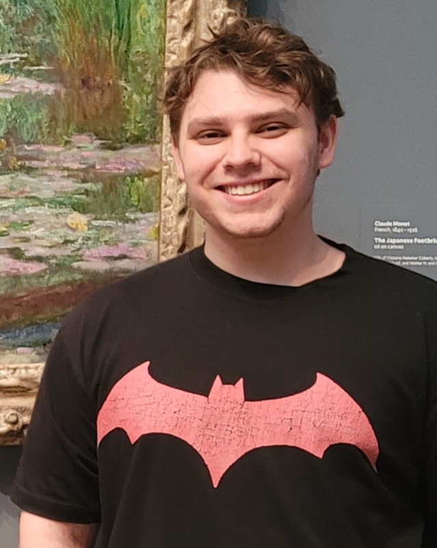 Picture of young college male wearing a black Batman t-shirt and smiling - this is Takoma Graham.